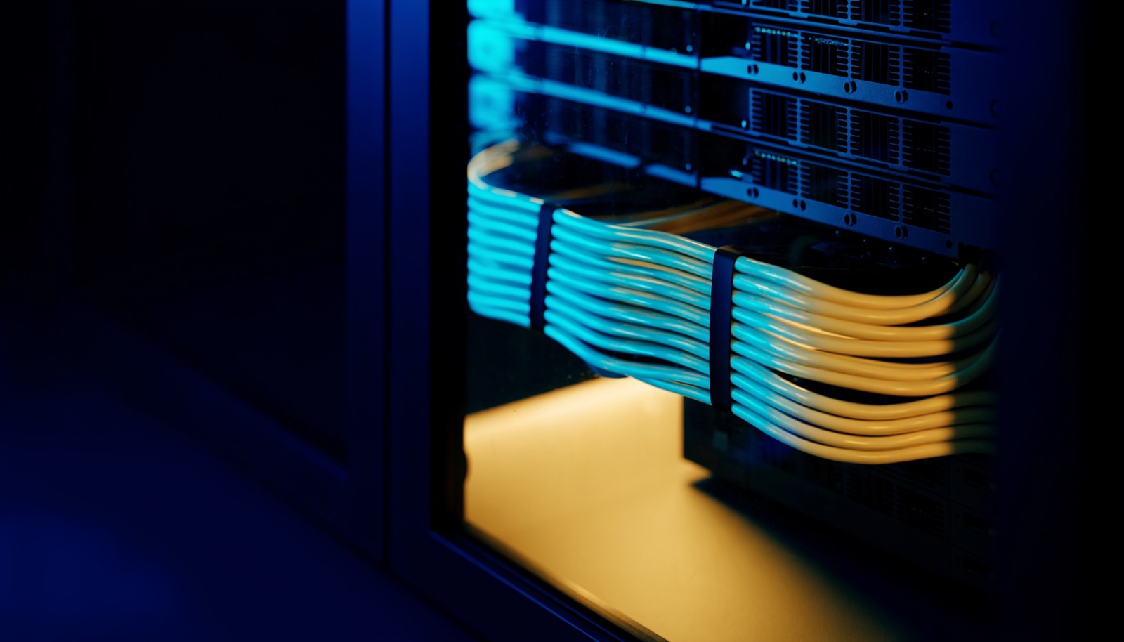 A small on-premises server rack with neatly dressed cyan-lit cabling